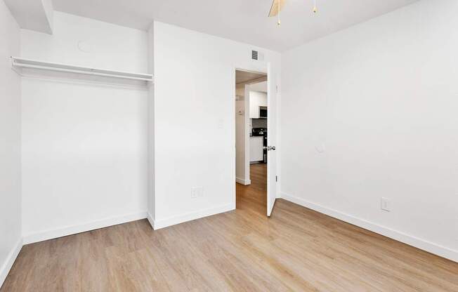 A white room with a sliding door and wooden flooring.