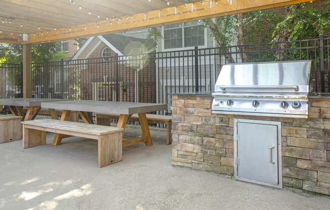 an outdoor kitchen with a grill and picnic table