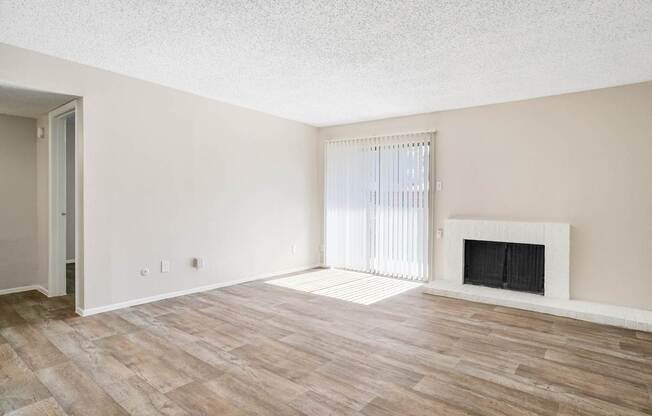 A room with a fireplace and wood flooring.