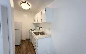 an empty kitchen with a sink and a refrigerator