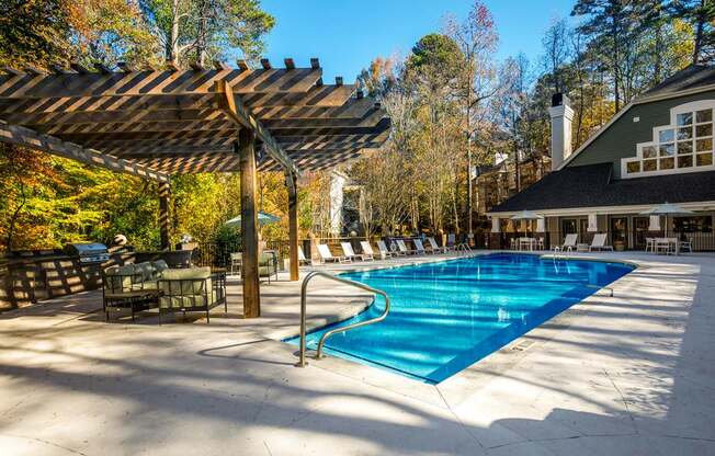 a swimming pool with chairs and umbrellas around it