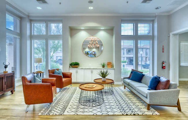 A living room with a grey sofa, a coffee table, and a chandelier.