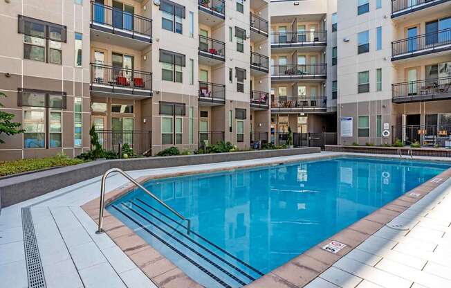 A swimming pool in front of apartment buildings.