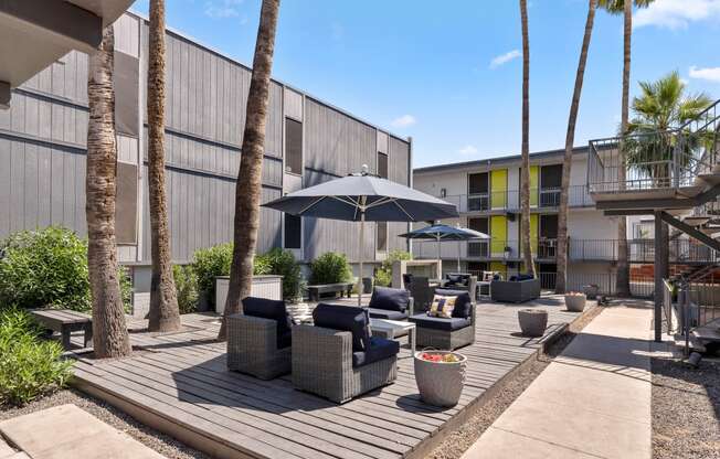 a patio with chairs and umbrellas at the bradley braddock road station apartments