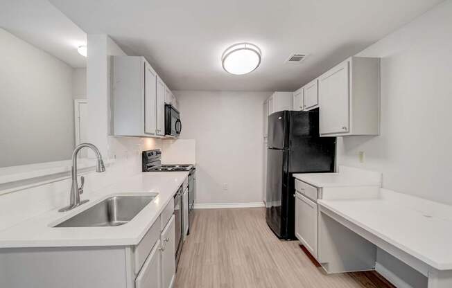 A kitchen with black appliances and wooden cabinets.
