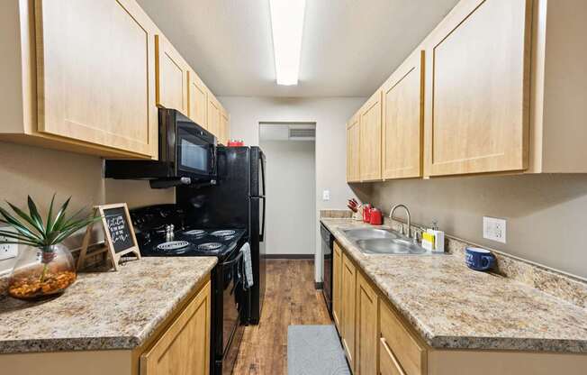A kitchen with a black stove top oven and a black microwave.