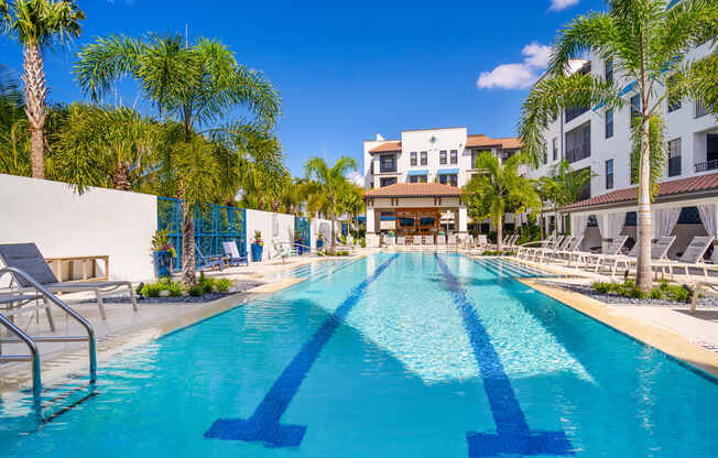 blue pool surrounded by white buildings at Magnolia Square, Naples, FL, 34109
