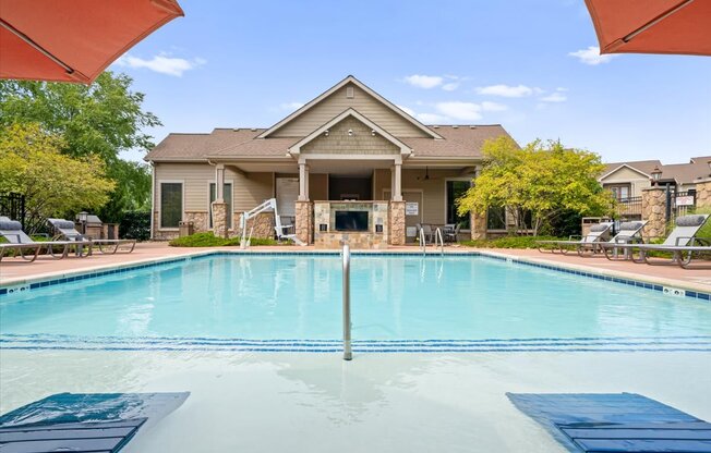 A swimming pool in front of a house.