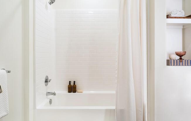 Select bathrooms feature a tub and shower combination with classic tile surrounds, modern fixtures, and a clean, contemporary design.