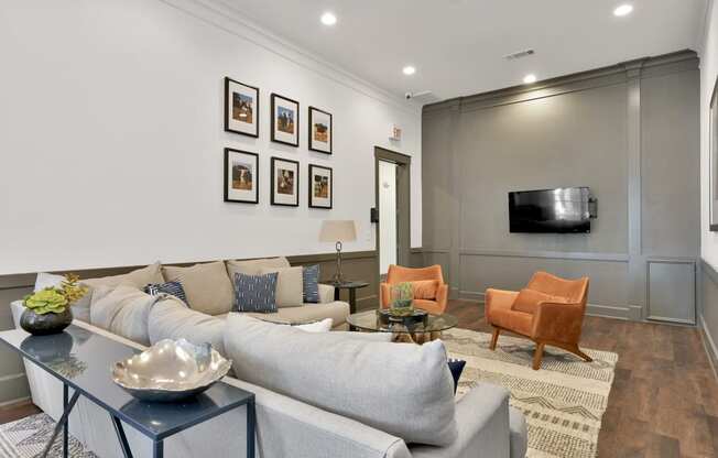 a living room with a gray couch and a tv on the wall