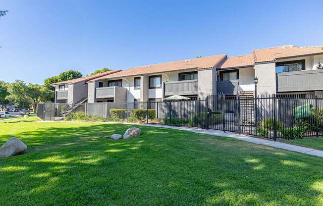 A row of houses with a green lawn in front.