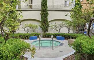 A small pool surrounded by bushes and trees.