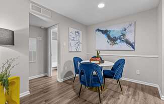 A dining room with a table and chairs.
