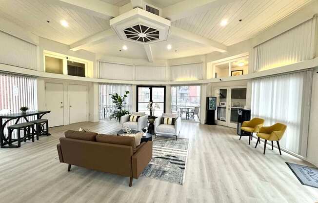 A spacious living room with a brown sofa and a yellow chair.