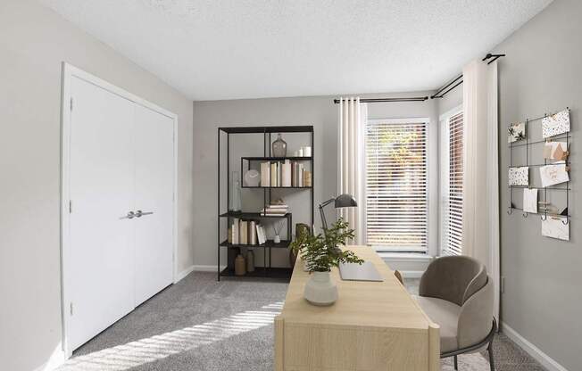 A room with a desk, chair, and bookshelf.