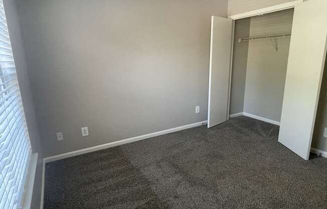 A room with grey carpet and a white door.