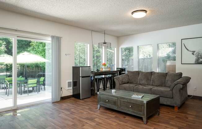 a living room with a couch and a table in front of a sliding glass door