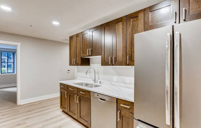 a kitchen with wooden cabinets and a stainless steel refrigerator