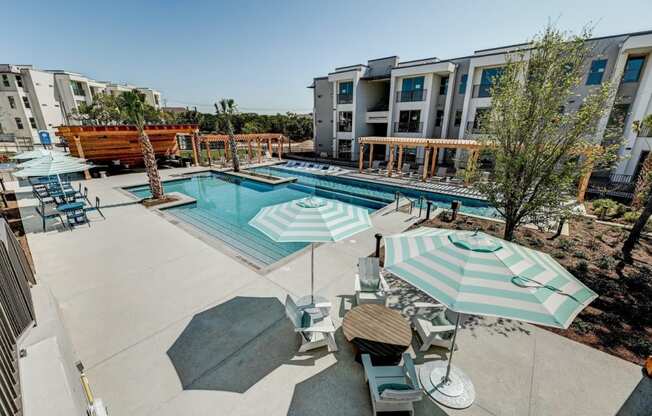 apartments with a pool and patio with umbrellas