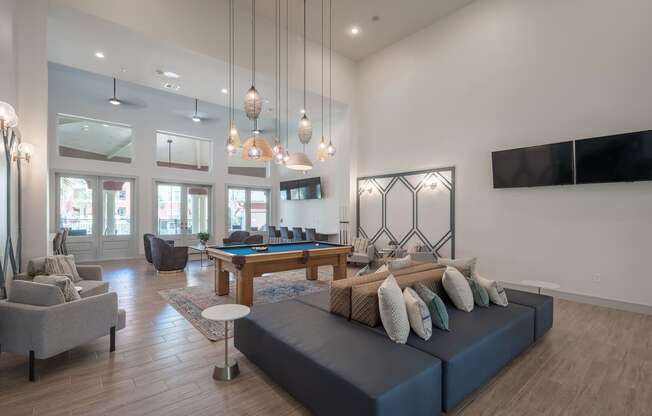 a living room with a blue couch and a pool table