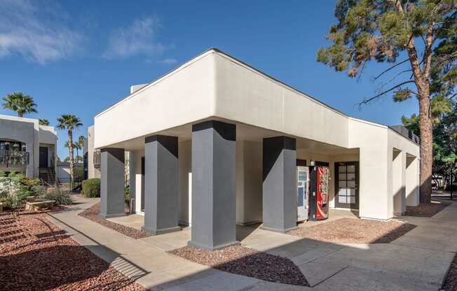 A modern building with a flat roof and a series of pillars in front.
