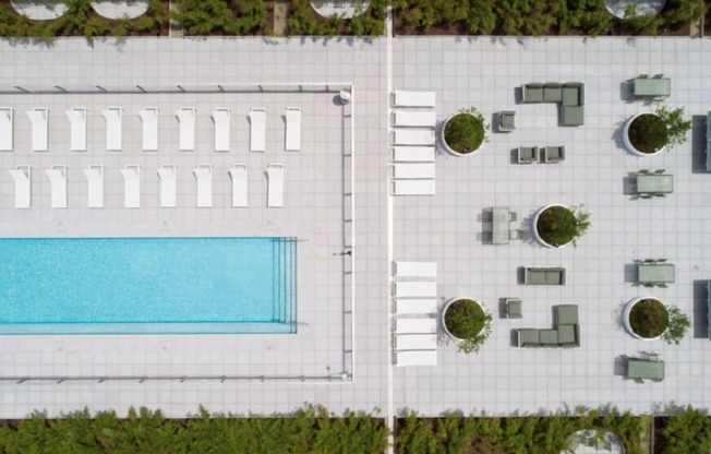 A swimming pool is surrounded by a white wall and a white fence.
