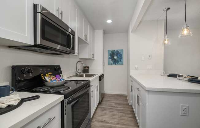 a kitchen with white cabinets and a black stove top oven