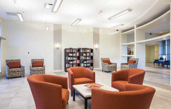 A room with orange chairs and a white table at Hummingbird Pointe & The Gardens, Parma, OH
