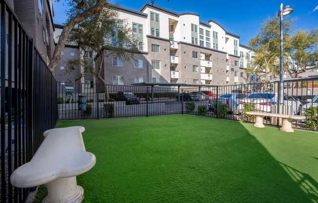 A white sculpture sits on a green lawn in front of a building.
