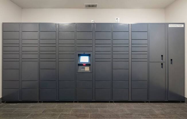 A bank of package lockers with a digital screen in the middle at Clackamas Trails Apartments, Oregon, 97222