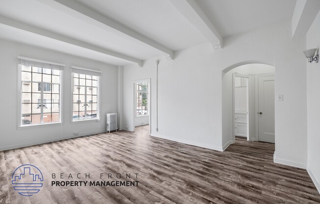 a renovated living room with white walls and wood flooring