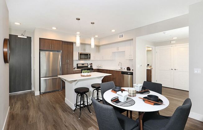 a kitchen and dining room with stainless steel appliances and a white table