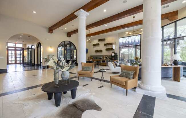 the lobby of a house with large columns and a living room