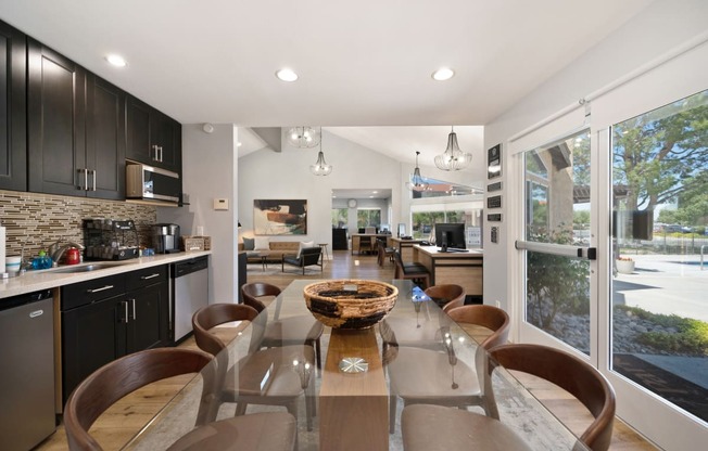 a kitchen and dining room with a glass table and chairs