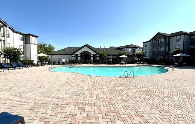 a large swimming pool in front of an apartment building