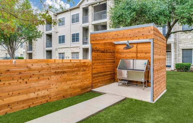 a small cabin with a grill in the backyard of an apartment building