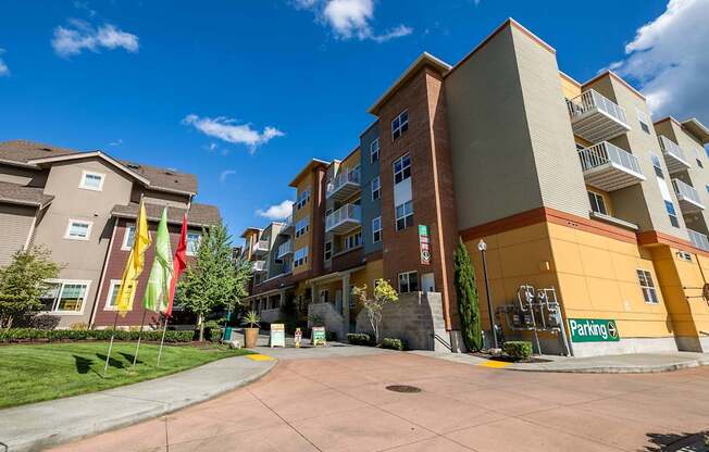 A parking lot in front of a multi-story apartment building.