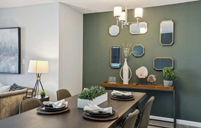 a dining room with a table and chairs and a wall with mirrors