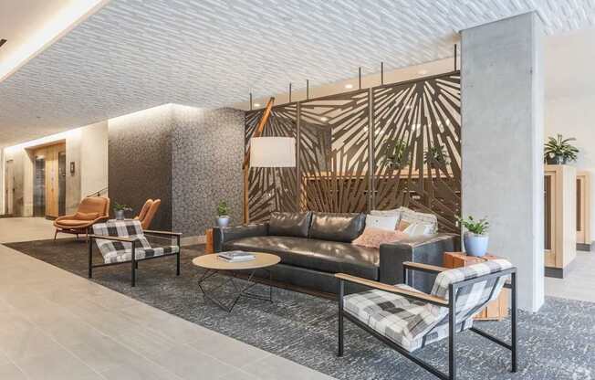 A modern living room with a black couch and a wooden wall panel.