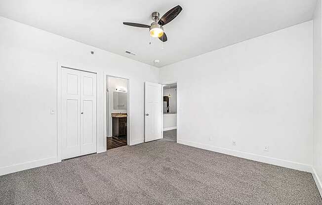 an empty bedroom with a ceiling fan at Trade Winds Apartment Homes in Elkhorn, NE 68022