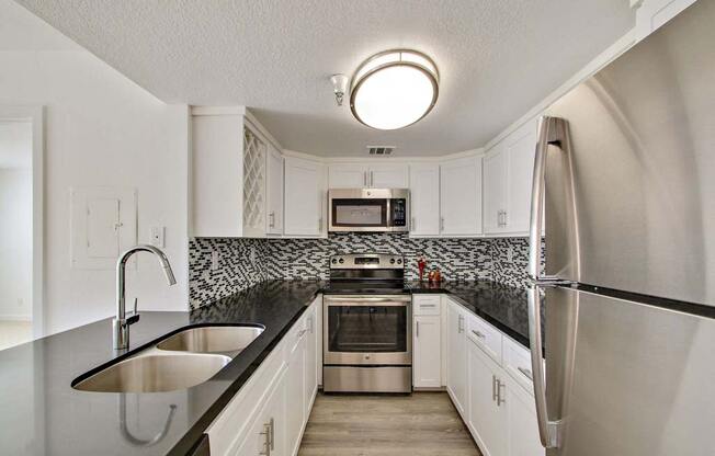 a kitchen with a sink and a refrigerator  at Masselin Park West, California