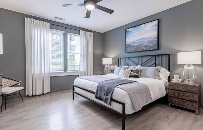 Spacious primary bedroom with dark gray walls and ceiling fan at Novel Cary