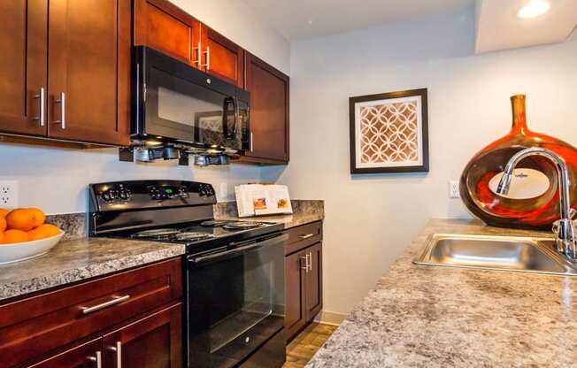 a kitchen with black appliances and granite counter tops at Skyview Apartments, Westminster, 80234