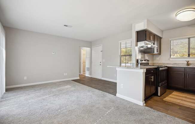an empty kitchen and living room with a kitchen counter top and