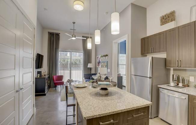 a kitchen with an island and a living room with a refrigerator