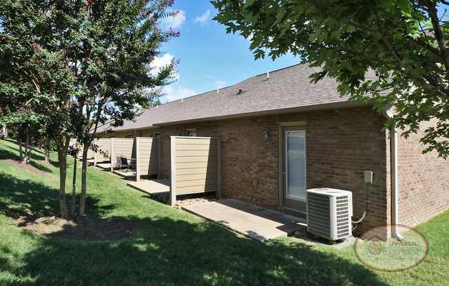 The rear of an apartment home building with back patios.