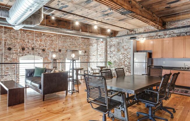 View of Business Center, Showing Meeting Table, Chairs, Sitting Areas, and Community Kitchen at Alpha Mill Apartments