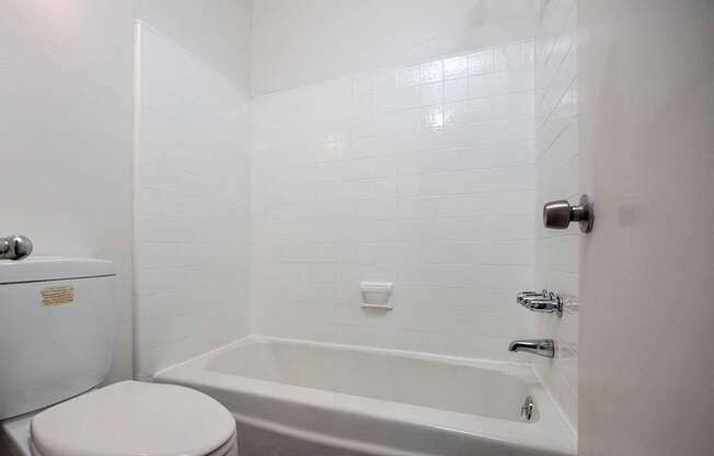 a white bathroom with a tub and a toilet
