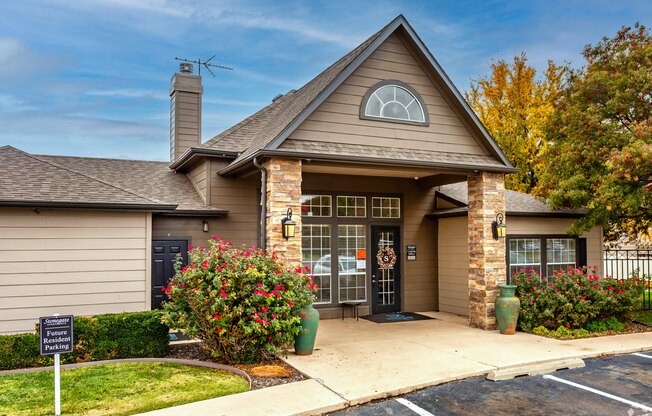 A small building with a black door and a sign in front.
