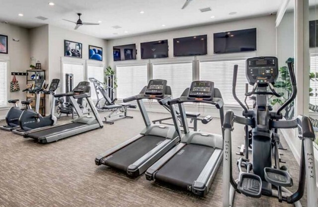 Fitness center with 3 treadmills, 2 stationary bikes, elliptical, and 4 flat screen televisions